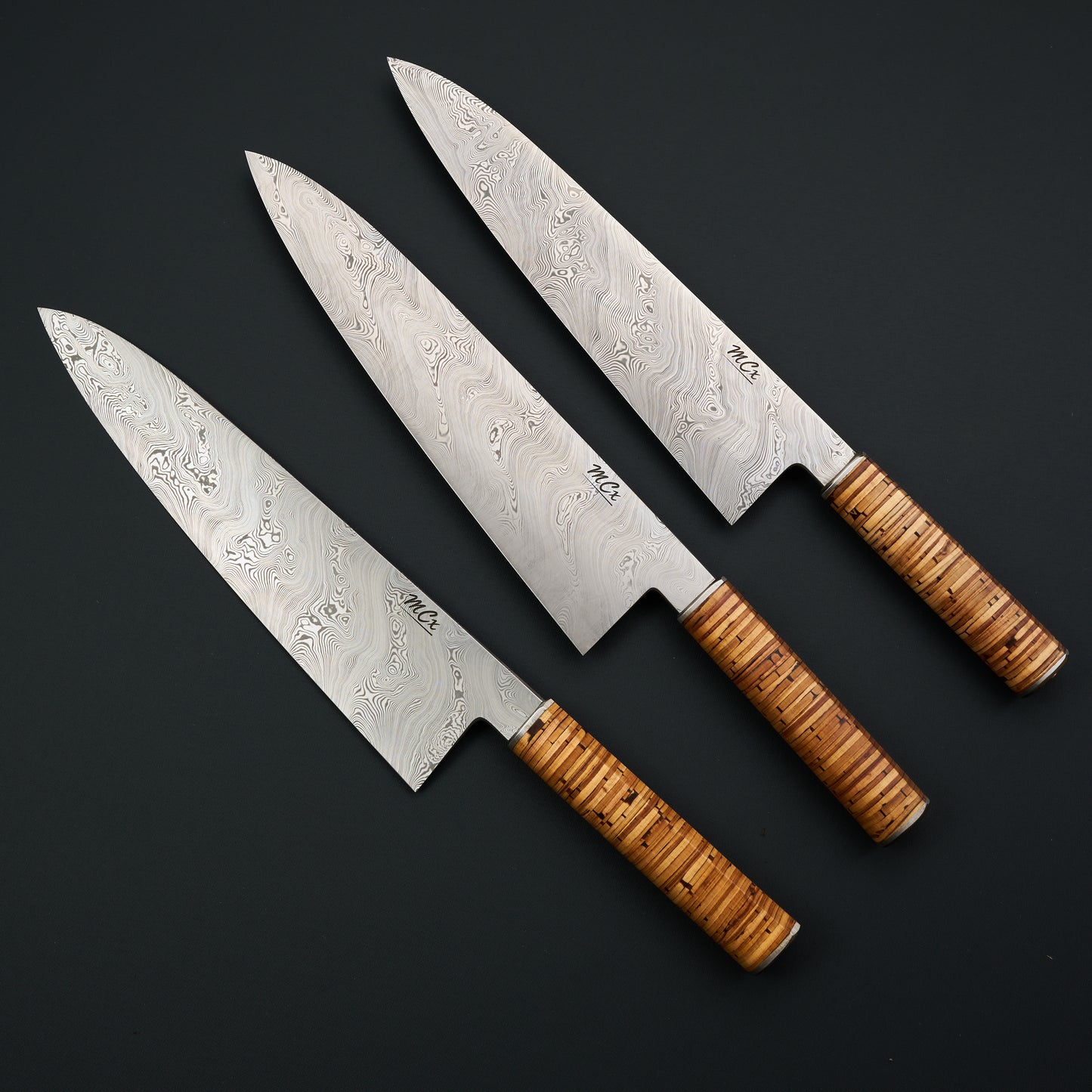 Three MCx Edition 01 gyutos with stacked birch-bark handles