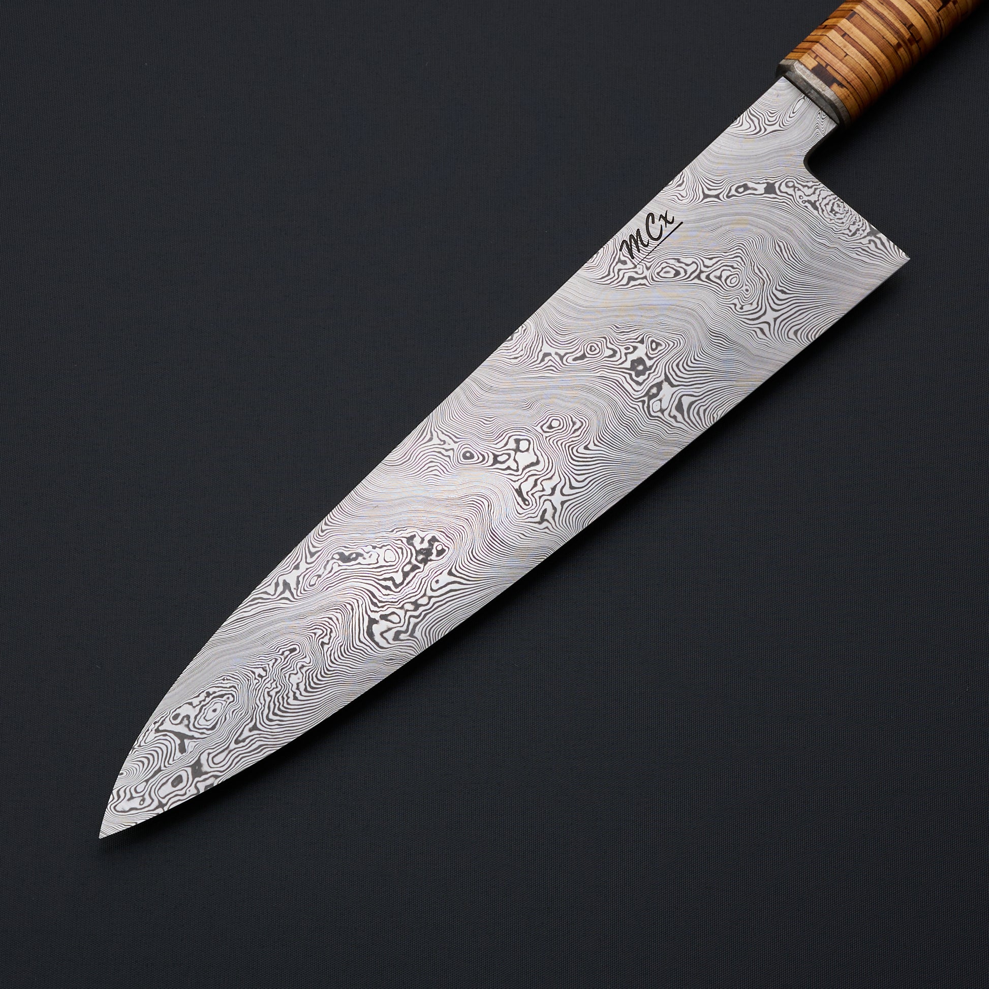 MCx Johnsson × Krichbaum 240mm Björkmans Twist gyuto, blade face and stacked birch-bark handle