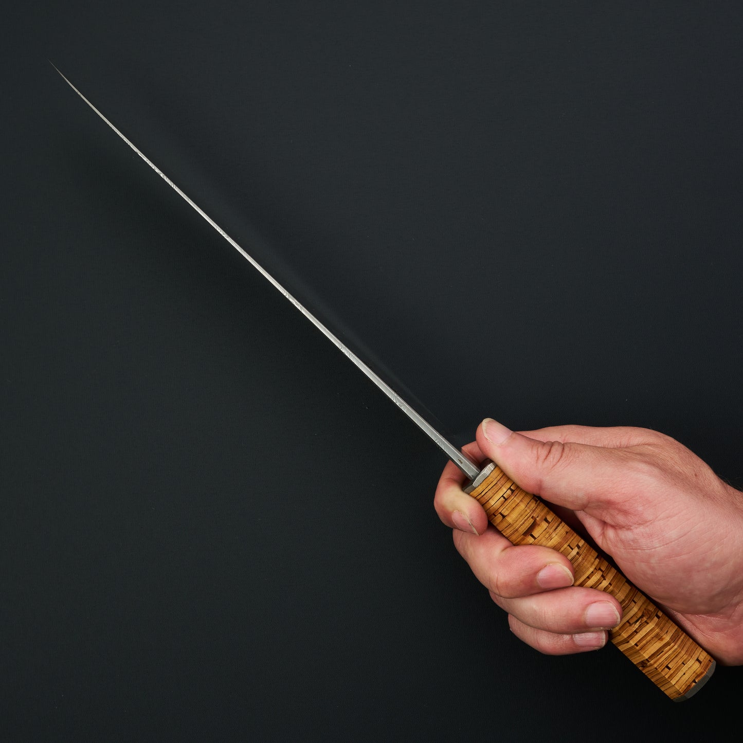 Spine view showing the aggressive distal taper towards the gyuto’s fine tip